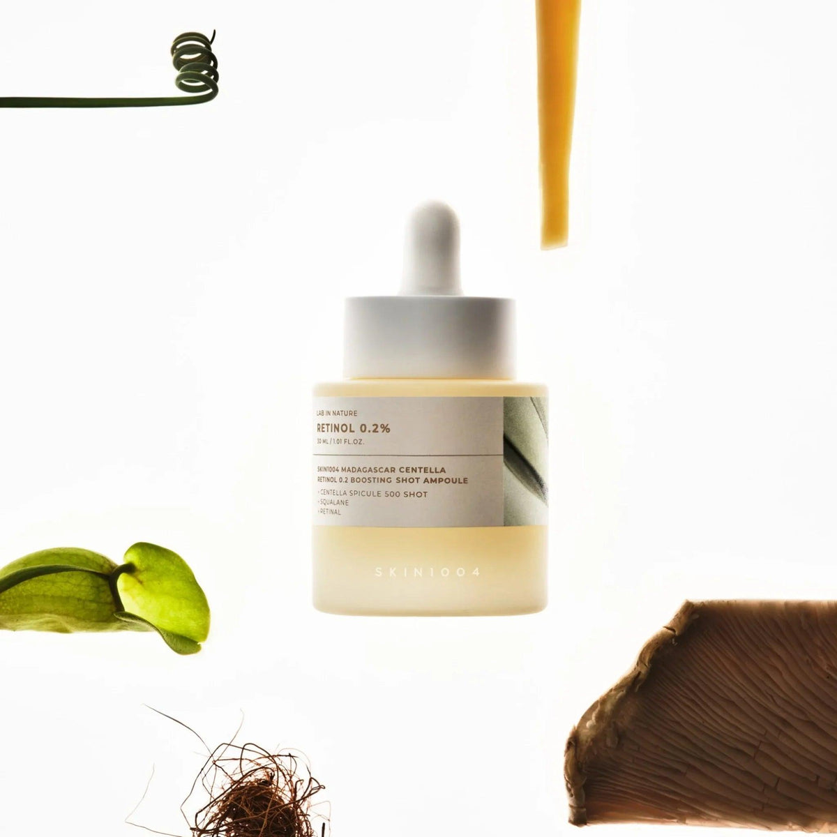 Ampolla de suero retinol 0.2% SKIN1004 con ingredientes naturales sobre fondo blanco