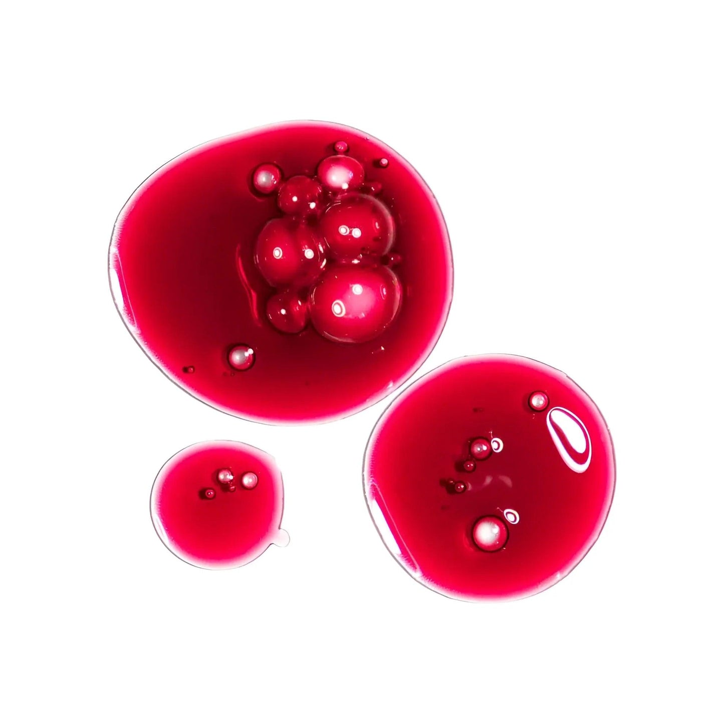 Gotas rojas brillantes con burbujas sobre fondo blanco, líquido vibrante y color intenso