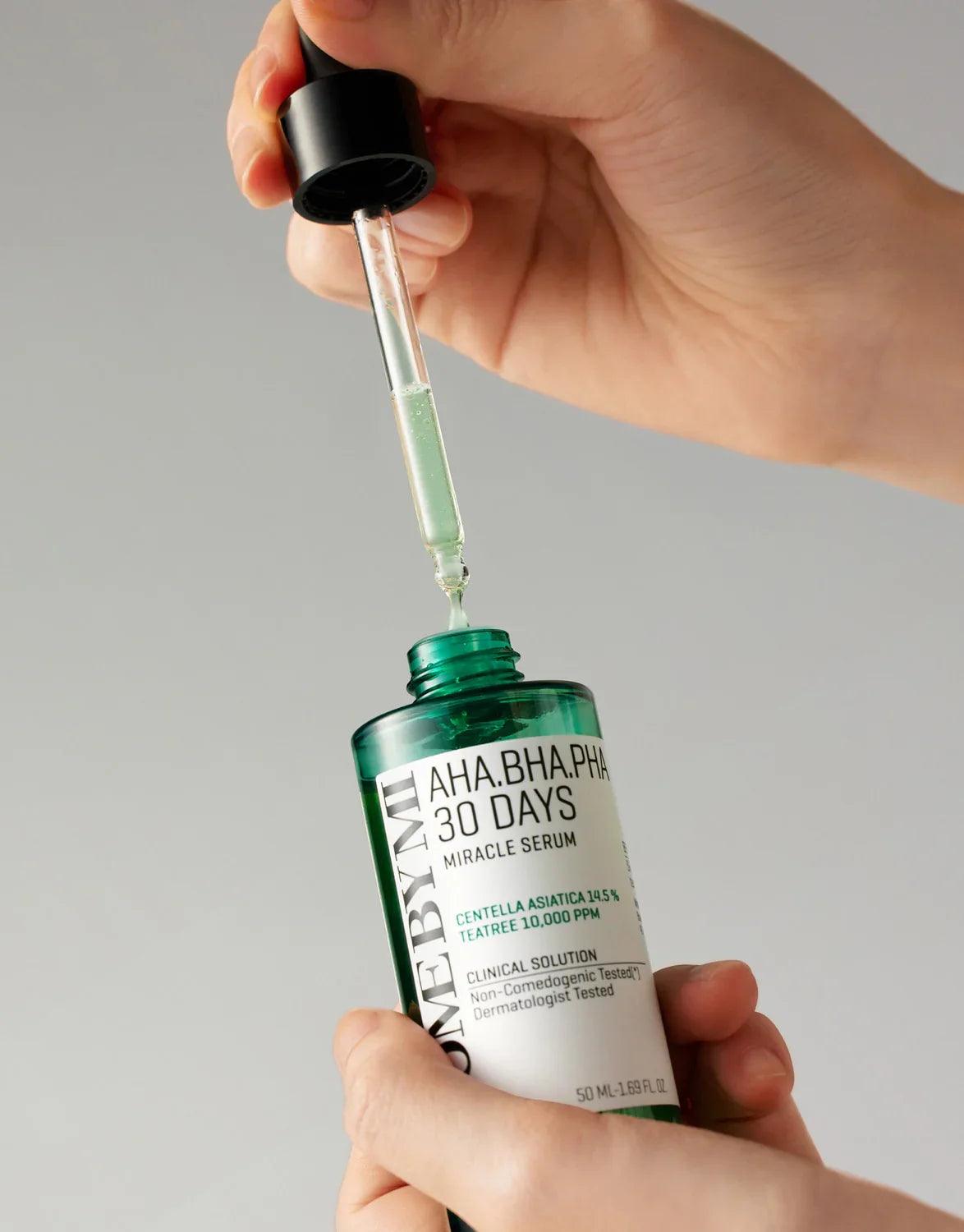 Sérum facial AHA BHA PHA 30 Days en botella verde con gotero, mano sosteniendo y gota de producto