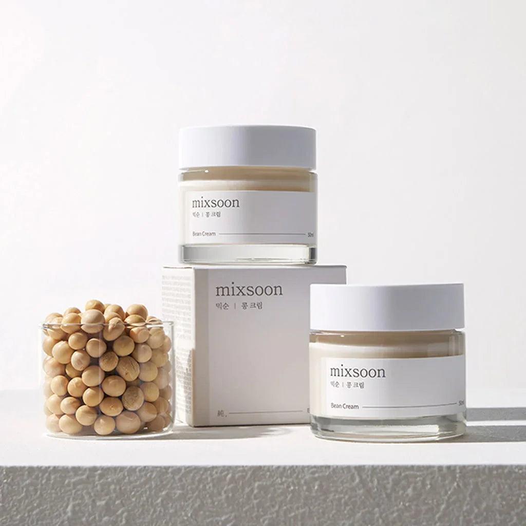 Crema facial Mixsoon Bean Cream en frascos con tapa blanca junto a recipiente con semillas de soja