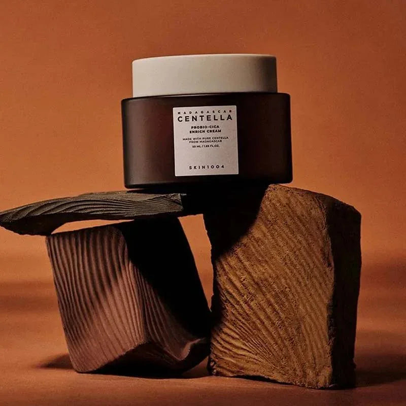 Crema enriquecida Madagascar Centella Probio-Cica SKIN1004 sobre bloques de madera con fondo marrón