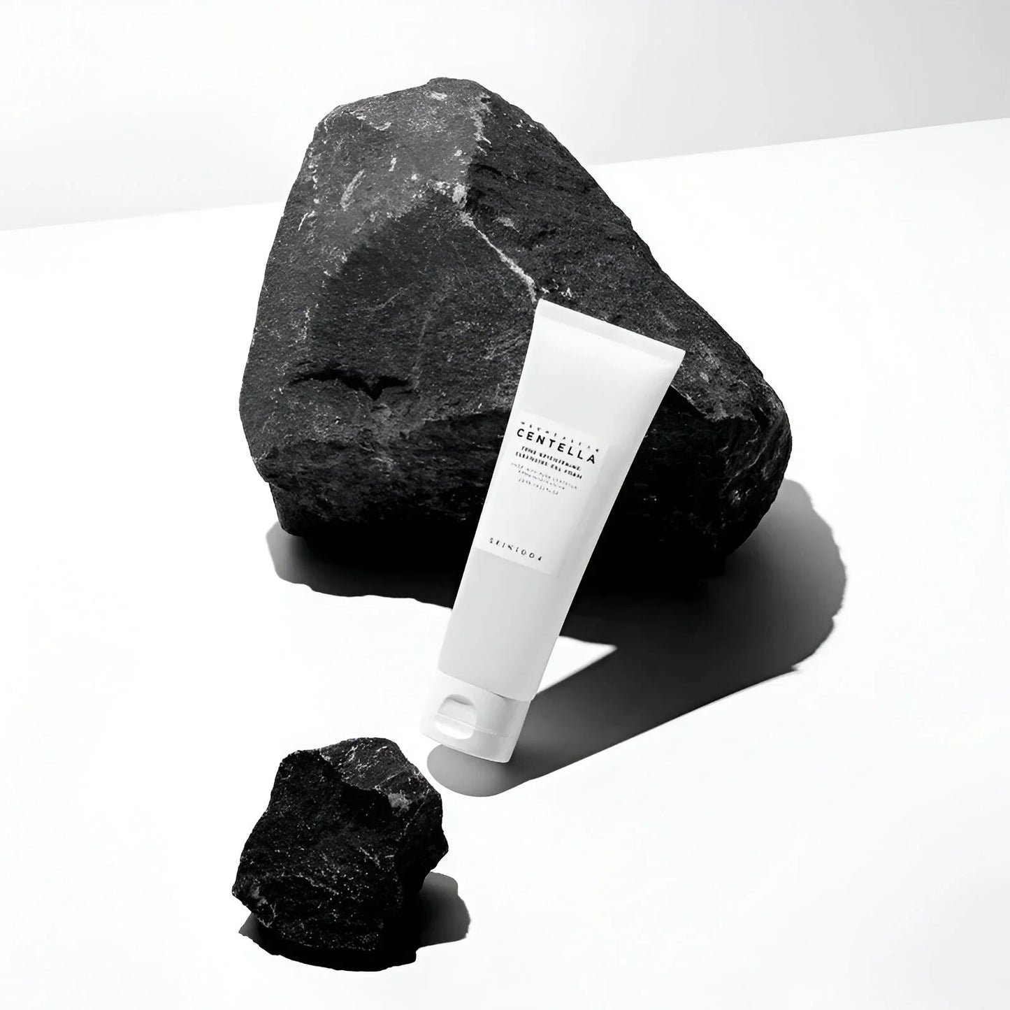 Gel limpiador facial Skin1004 Centella Madagascar en tubo blanco con piedras negras grandes