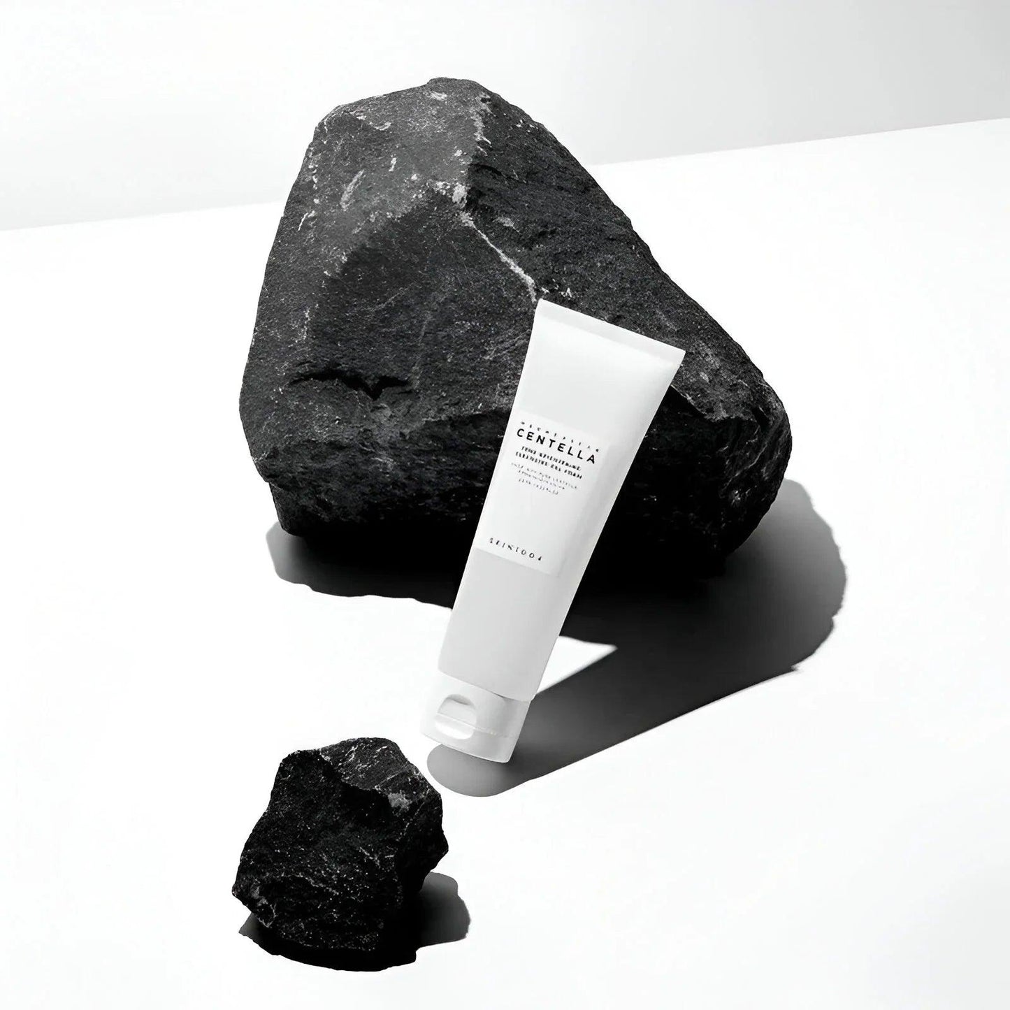 Gel limpiador facial Skin1004 Centella Madagascar en tubo blanco con piedras negras grandes