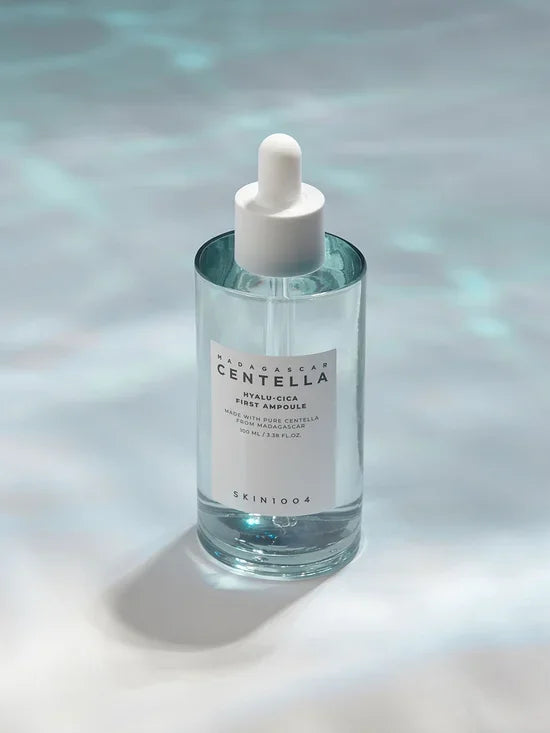 Botella de serum Skin1004 Madagascar Centella Hyalu-Cica First Ampoule con gotero sobre fondo claro
